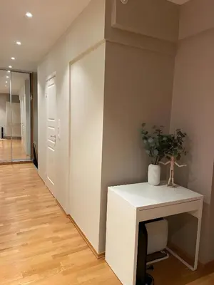 a hallway with a white table with a plant on it at Lovely 3-room gem in the heart of Bergen City in Bergen