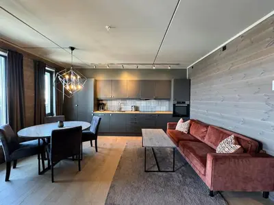 a living room with a red couch and a table at Riddertunets stilfulle in Beitostøl