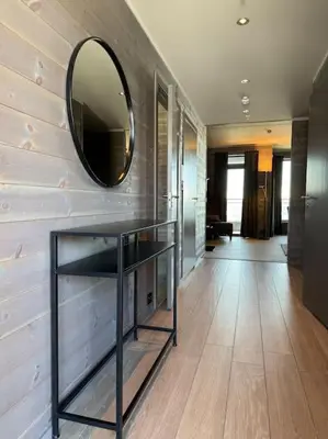 a hallway with a mirror on a wall with a shelf at Riddertunets stilfulle in Beitostøl