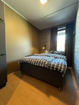 a bedroom with a bed in a room with a window at Riddertunets hygge in Beitostøl