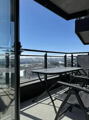 a table and chairs on the balcony of a building at Riddertunets hygge in Beitostøl