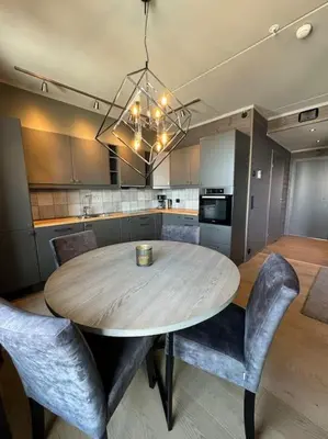 a kitchen with a wooden table and some chairs at Riddertunets utsikt til Mugnetind in Beitostøl