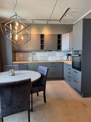 a kitchen with a table and chairs and aendant light at Riddertunets utsikt til Mugnetind in Beitostøl