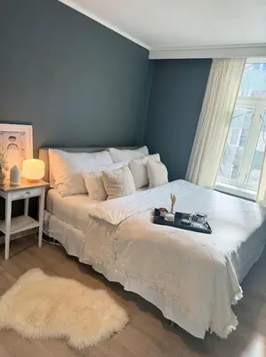 a bedroom with a large white bed and a window at Sentral og koselig leilighet i Trondheim in Trondheim