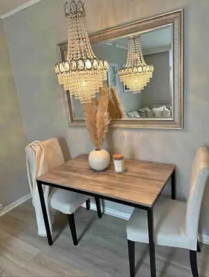 a dining room table with a vase and a mirror at Sentral og koselig leilighet i Trondheim in Trondheim