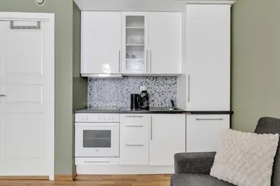 a kitchen with white cabinets and a stove at City Retreat in Bergen