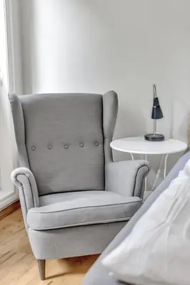 a gray chair sitting in a bedroom next to a table at City Retreat in Bergen