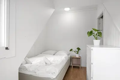 a white room with a bed with white sheets at City center apartment with teracce in Bergen