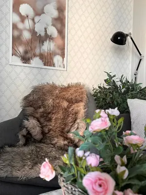 a teddy bear sitting on a couch next to flowers at Det lille huset i Slipveien in Bud