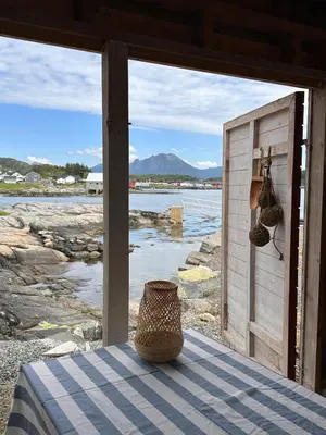 a room with a table with a view of the water at Det lille huset i Slipveien in Bud