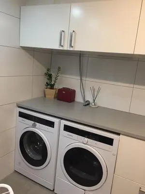 a kitchen with a washer and dryer in a kitchen at Exclusive three-story villa near the ski center in Trondheim