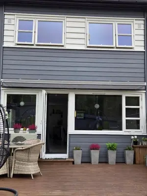 a house with windows and potted plants on a patio at Exclusive three-story villa near the ski center in Trondheim