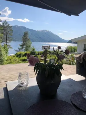 a vase on a table with a view of the water at PARADISET - a beautiful pearl 1,45 minutes from Trondheim in Surnadal