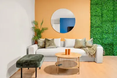 a living room with a white couch and a round mirror at Dinbnb Apartments l Free Parking l 5 Min From Torget l Nearby Coast I Newly Furnished in Bergen