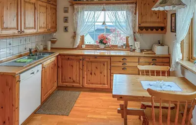 a kitchen with wooden cabinets and a wooden table at Lovely Home In Lena With Wifi