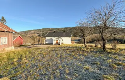 a white house in a field with a tree at Beautiful Home In Vestre Gausdal in Vestre Gausdal