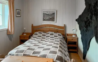 a bedroom with a bed and two night stands at Awesome Home In Lillehammer With Sauna in Lillehammer