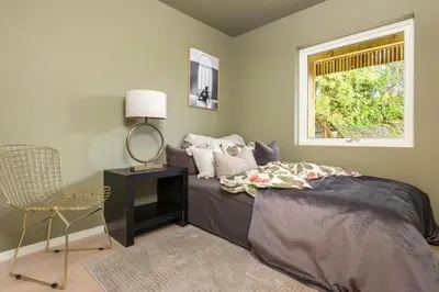 a bedroom with a bed and a chair and a window at Flott bolig til VM! Gåavstand in Trondheim