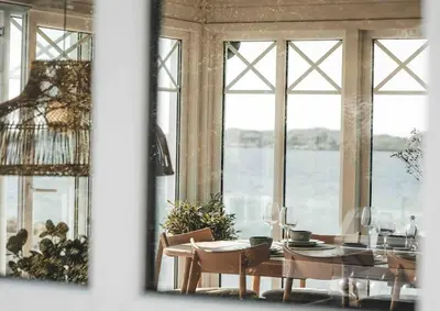 a dining room with a table and some windows at Paradise by the Seaside in Hitra