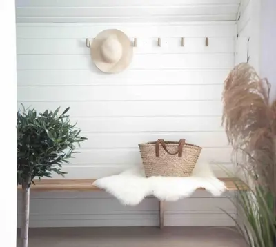 a straw hat sitting on a bench with a basket at Paradise by the Seaside in Hitra