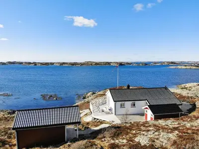 a house on the shore of a body of water at Paradise by the Seaside in Hitra