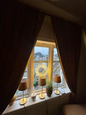 a window with two lamps and a wreath on it at Historical house with view and separate entrance in Ålesund
