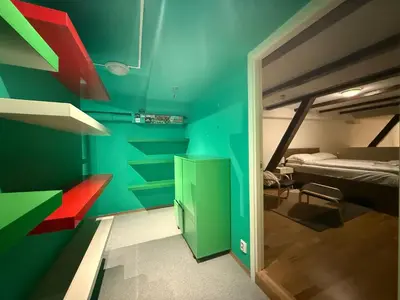 a room with a green wall with a bed and a doorway at Charming Loft, High Ceiling !Modern & Central, Free private Parking 7 min walking ! in Trondheim