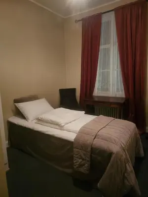 a bed sitting in a bedroom with a window at Eides Hotel in Høyanger