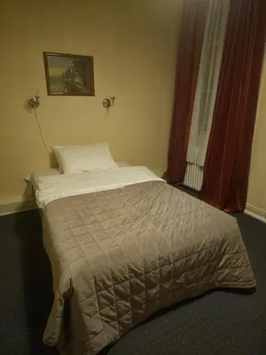 a small bed in a room with a window at Eides Hotel in Høyanger