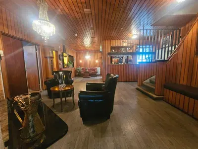 a living room with chairs and a chandelier at Eides Hotel in Høyanger