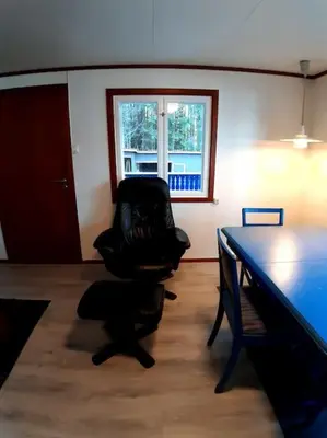 a black chair sitting in a room with a table at Koselig blått hus - utsikt Losna in Tretten