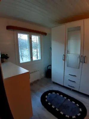 a kitchen with a refrigerator and a rug on the floor at Koselig blått hus - utsikt Losna in Tretten