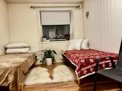 a room with two beds and a window at Ålesund room with shared shower in Ålesund