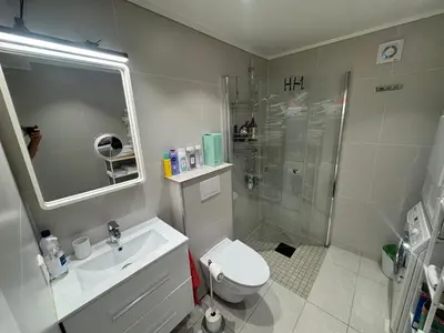 a bathroom with a shower and a toilet and a sink at Ålesund room with shared shower in Ålesund