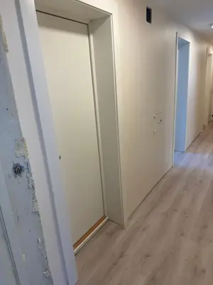 an empty hallway with white walls and a door at Ålesund room with shared shower in Ålesund