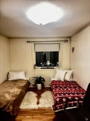 a room with two beds and a window with a man in the mirror at Ålesund room with shared shower in Ålesund