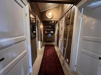 a hallway with a red rug and a clock on the ceiling at Welcoming Cabin With Fireplace & Modern Kitchen in Beitostøl