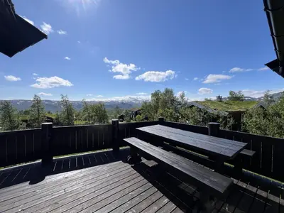 a wooden bench sitting on top of a wooden deck at Welcoming Cabin With Fireplace & Modern Kitchen in Beitostøl