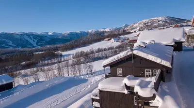 a house covered in snow on a mountain at Charming Getaway ,Near Ski Trails And Hiking Paths in Beitostøl