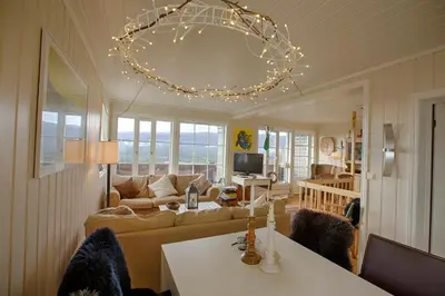 a living room with a couch and a chandelier at Charming Getaway ,Near Ski Trails And Hiking Paths in Beitostøl