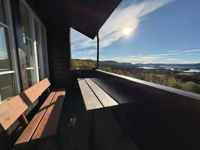 a wooden bench sitting on the porch of a house at Charming Getaway ,Near Ski Trails And Hiking Paths in Beitostøl