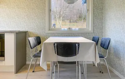 a table and chairs with a white table and a window at 3 Bedroom Nice Home In Mjosundet in Ertvåg