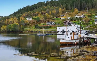 a boat docked at a dock in a body of water at 3 Bedroom Nice Home In Mjosundet in Ertvåg