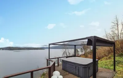 a bird bath on a deck next to a body of water at Amazing Home In Omastrand With Wifi in Gjuvsland