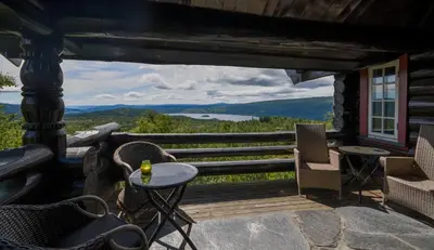a porch with chairs and a table with a view at Large Cabin with Stunning Views! in Beitostøl