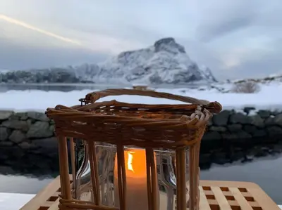 a wicker basket with a light in front of a mountain at Exclusive fjord getaway with sauna in Leirgulen