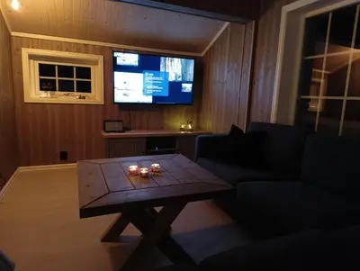 a living room with a coffee table and a tv at Hytte-23 Cozy cabin close to Kvitfjell in Fåvang