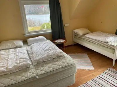two beds sitting in a room with a window at Oceanview House Ideal for Peaceful Holidays in Venøya
