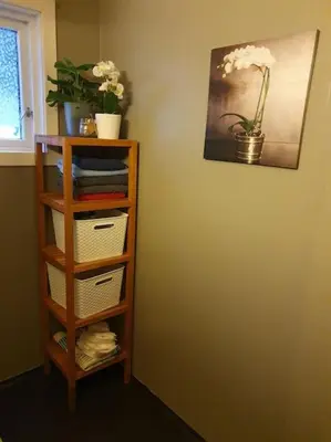 a book shelf with a vase of flowers on a wall at Oceanview House Ideal for Peaceful Holidays in Venøya