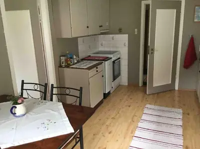 a kitchen with white appliances and a table and a table and chairs at Oceanview House Ideal for Peaceful Holidays in Venøya